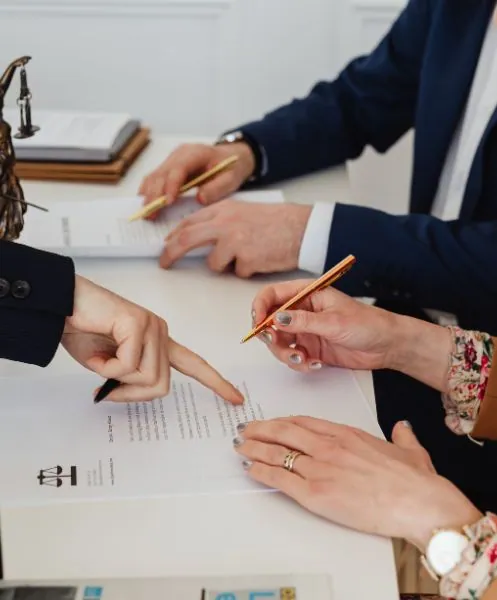 Abogada señalando dónde firmar en un acuerdo de divorcio a sus clientes | Efectos civiles y derecho eclesiástico en Zaragoza