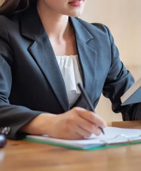 Abogada escribiendo en un documento | Derecho procesal en Zaragoza